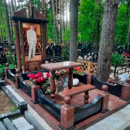 Мемориальный комплекс из красно-коричневого гранита: ограда с балясинами, стол и скамья