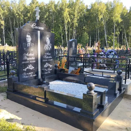 Двойной памятник из чёрного гранита с горизонтальной стелой и шарами на столбиках