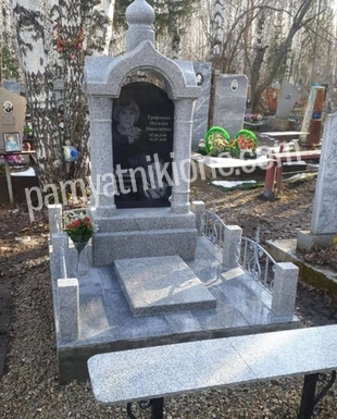 Памятник-часовня из светло-серого гранита с арочным верхом и плиткой