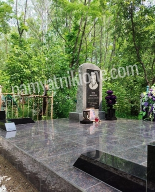 Небольшой светлый памятник с тёмной плитой и мраморной крошкой
