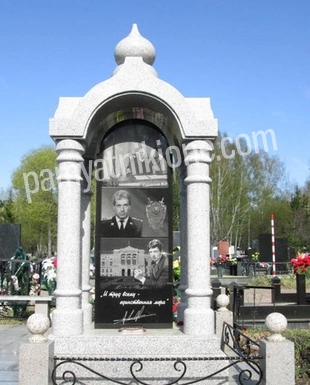 Памятник-часовня из белого мрамора с арочным навесом и кованой оградой