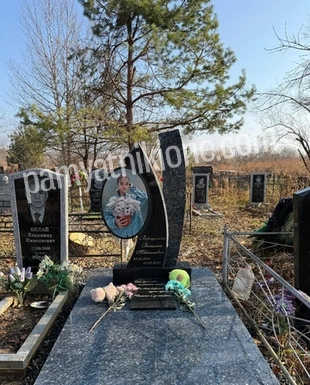 Двойной фигурный памятник из чёрного гранита с гравировкой и цветником