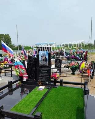 Мемориальный комплекс из чёрного гранита с искусственным газоном и цветником